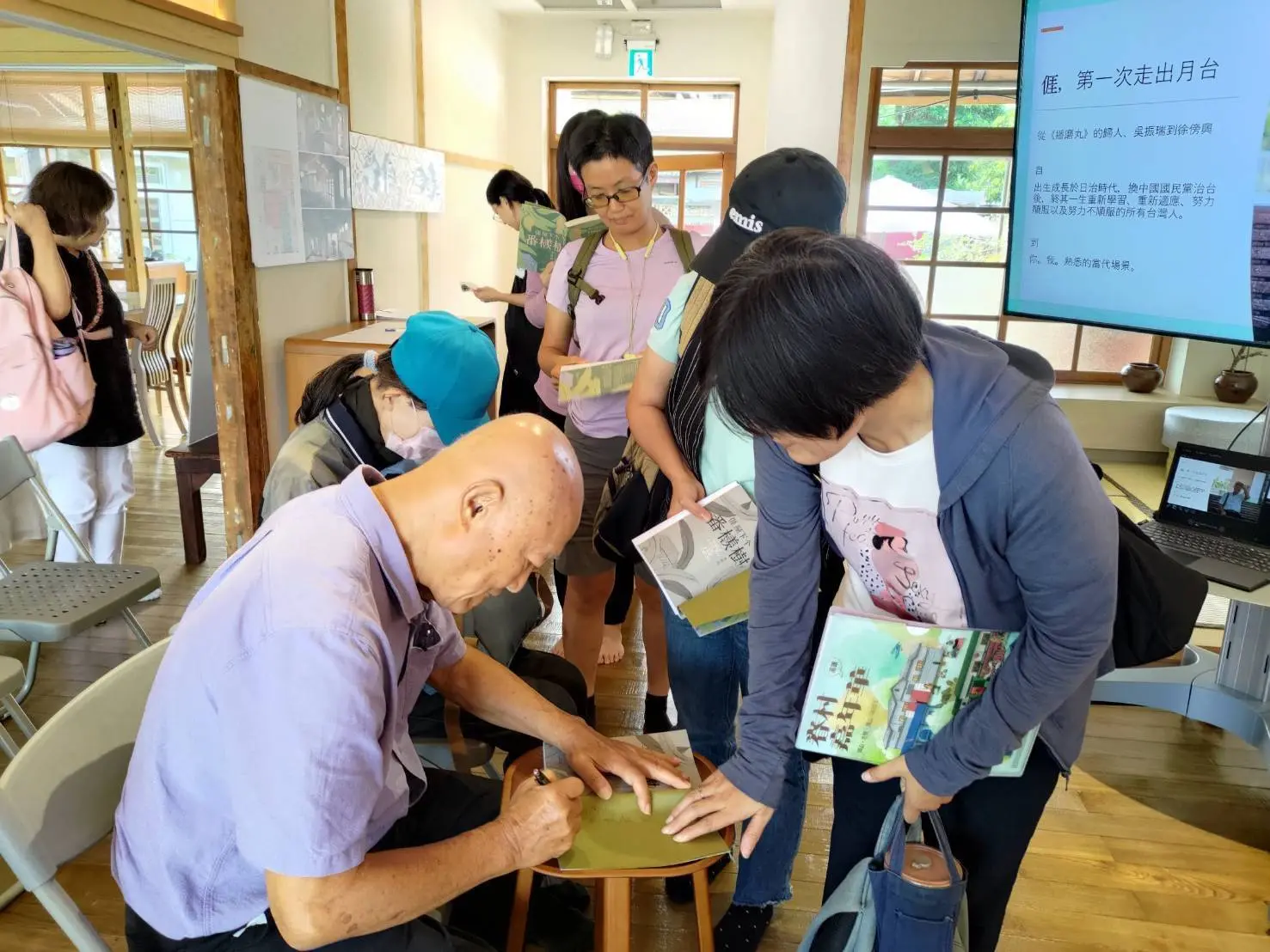 活動結束後民眾手捧書本排隊，邀請李旺台老師簽名留念。高雄客基會提供
