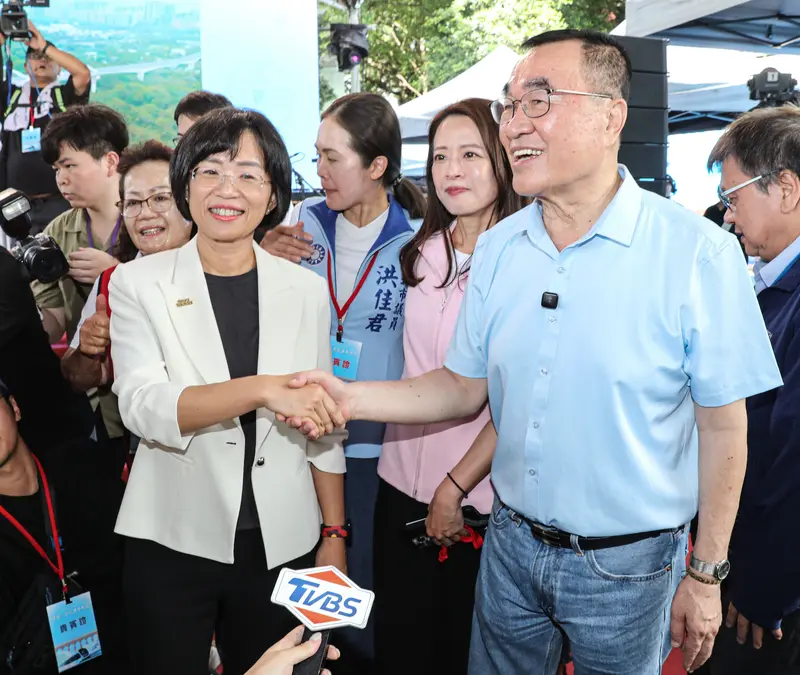 民進黨新北市長參選人蘇巧慧(前左)與國民黨新北市長參選人李四川(前右)30日出席新北捷運三鶯線通車典禮,會前握手寒暄。中央社