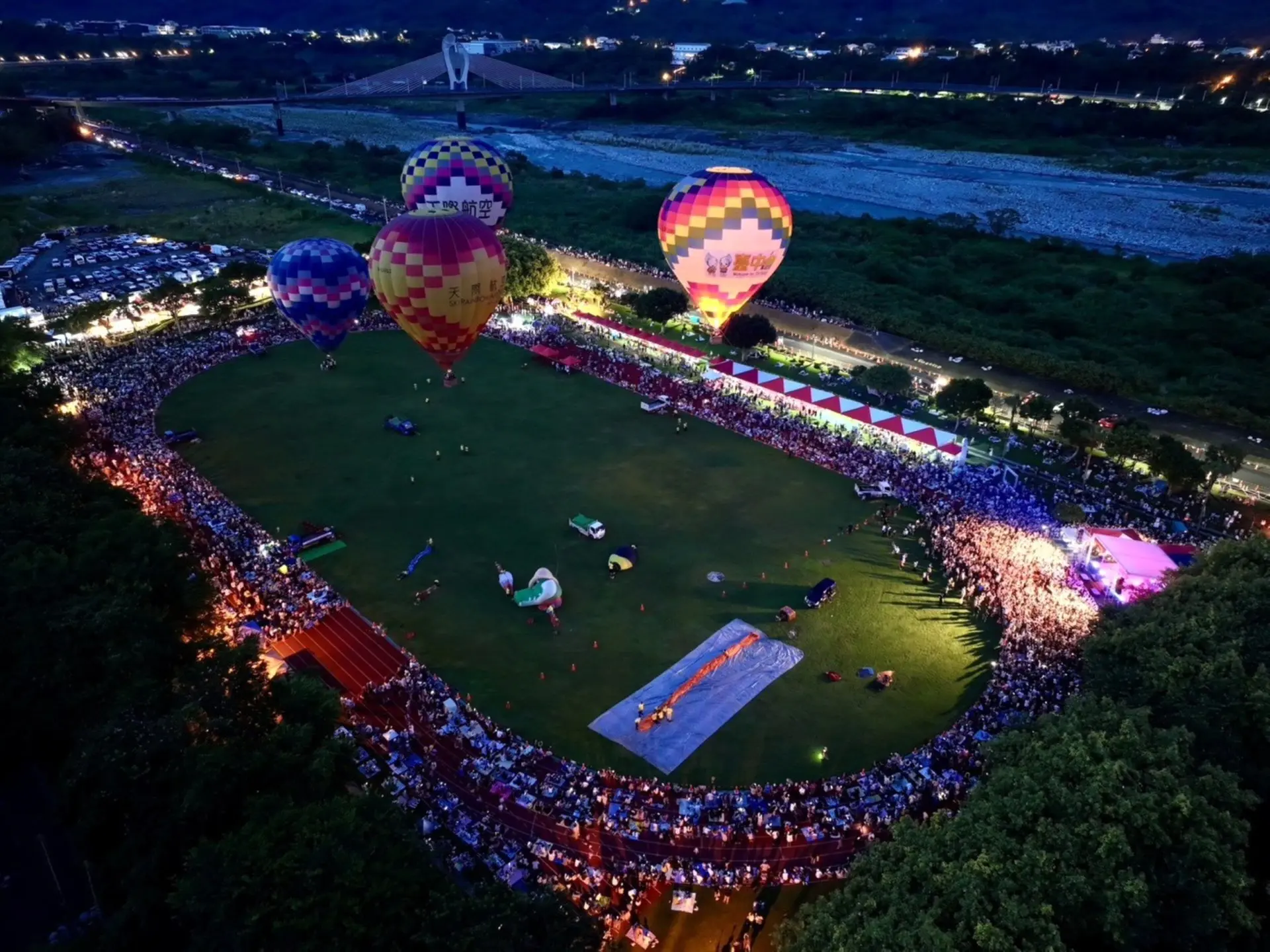 石岡熱氣球嘉年華從白天延續至夜晚，遊客觀賞熱氣球、欣賞音樂演出，感受山城魅力。台中市政府資料照片