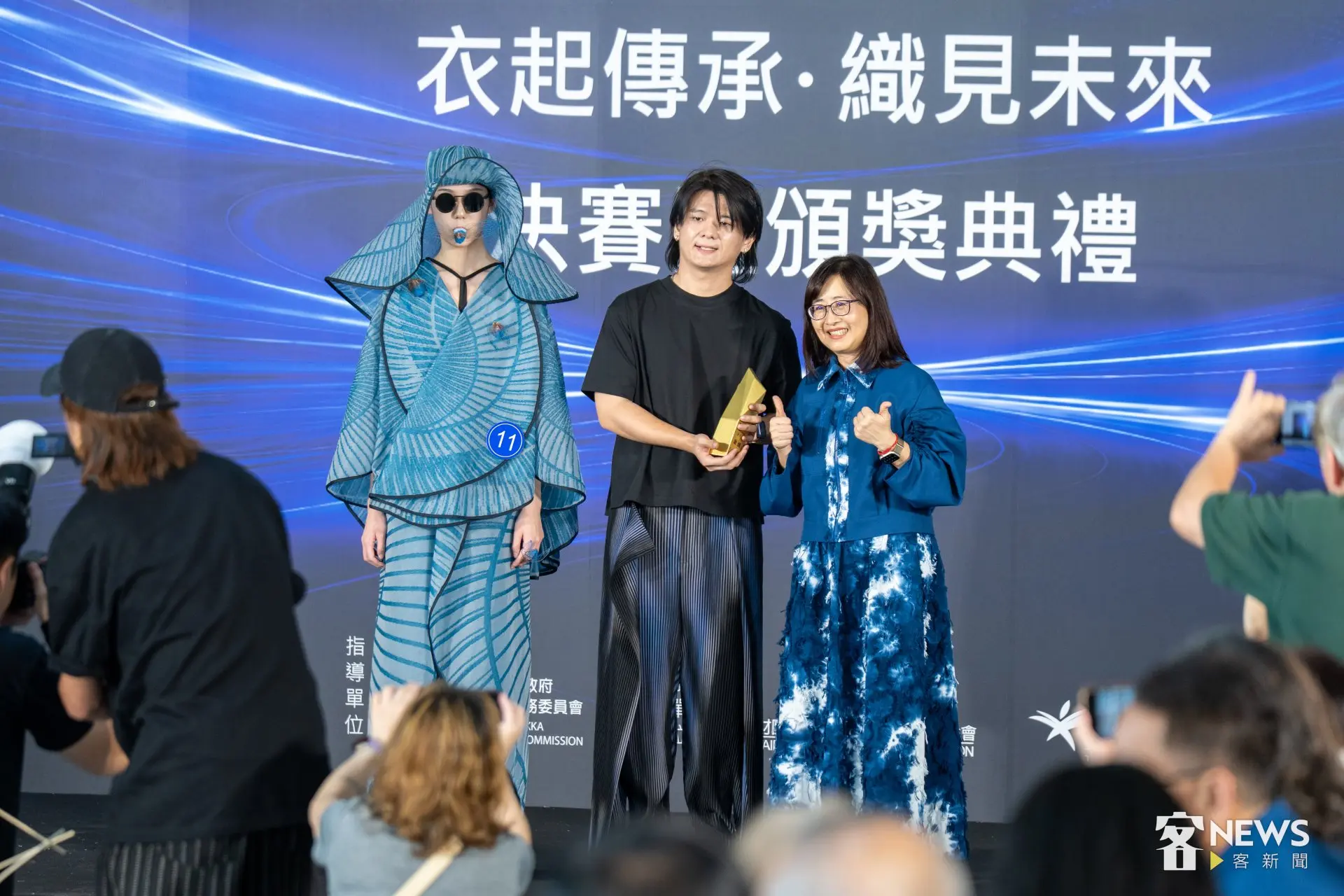 2026客家時尚獎最高榮譽金獎由設計師高元龍（中）以作品《蟬鳴客庄》（左）獲得，抱回35萬元獎金，並由台北市副市長林奕華（右）頒獎。李台源攝