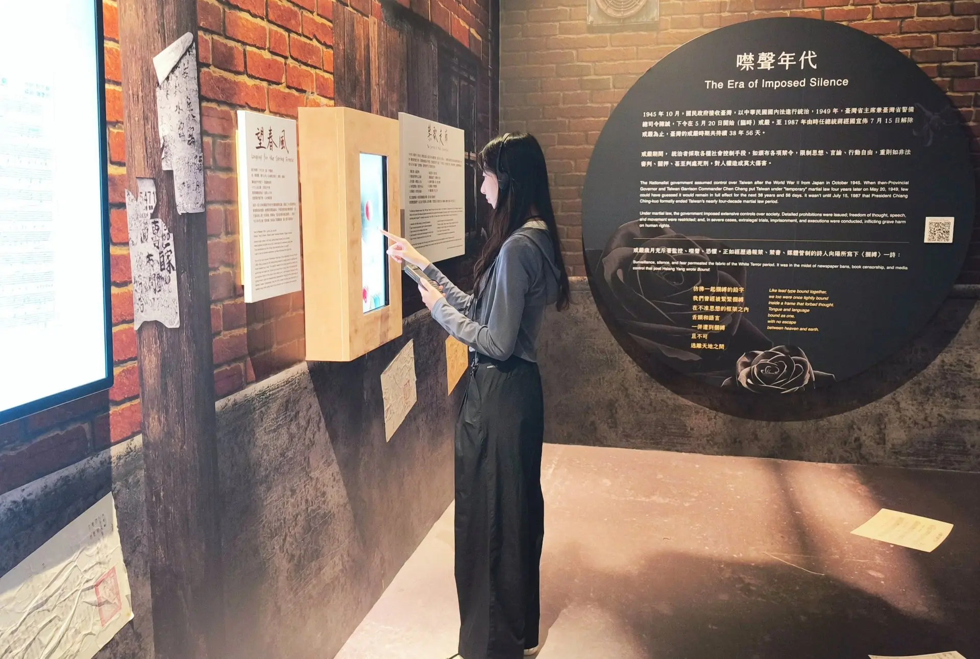 觀眾在「自由花蕊展–禁歌區」聽著語音導覽解說並操作互動裝置。國立中正紀念堂管理處提供