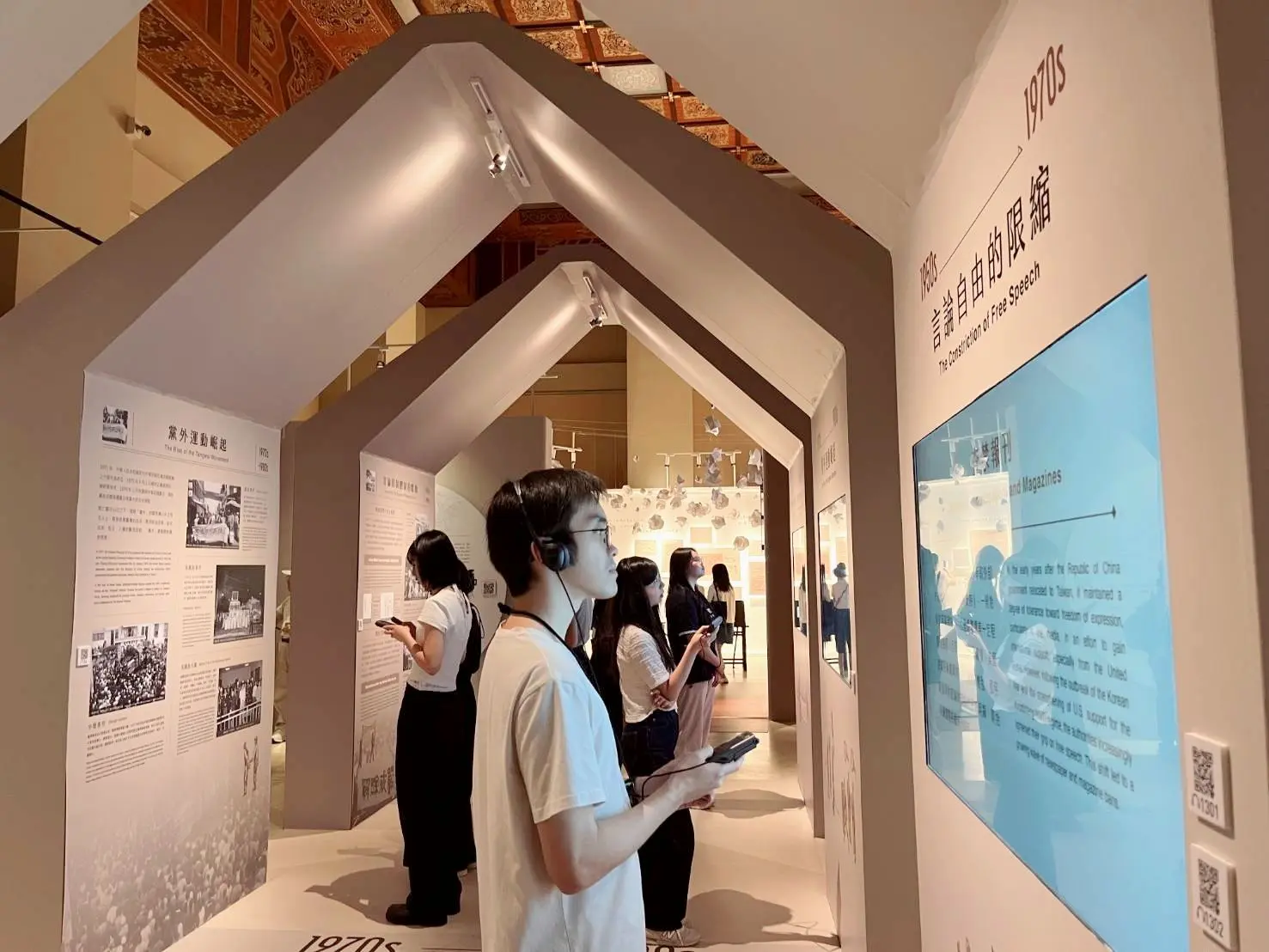 觀眾在「自由花蕊展」認真聆聽語音導覽解說。國立中正紀念堂管理處提供