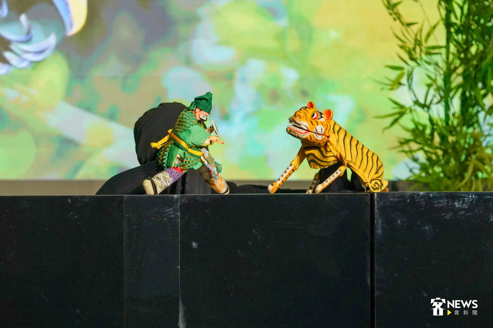 今天頒獎典禮開演表演,安排《台北木偶劇團》布袋戲與搖滾樂團《百合花》跨界合作,向3位得獎者致敬。第二段場景轉變到徐仁修的雨林攝影作品,看到戲偶化身徐仁修手持相機深入荒野,全身心投入記錄臺灣的自然生態與地景之美。洪藝晅攝