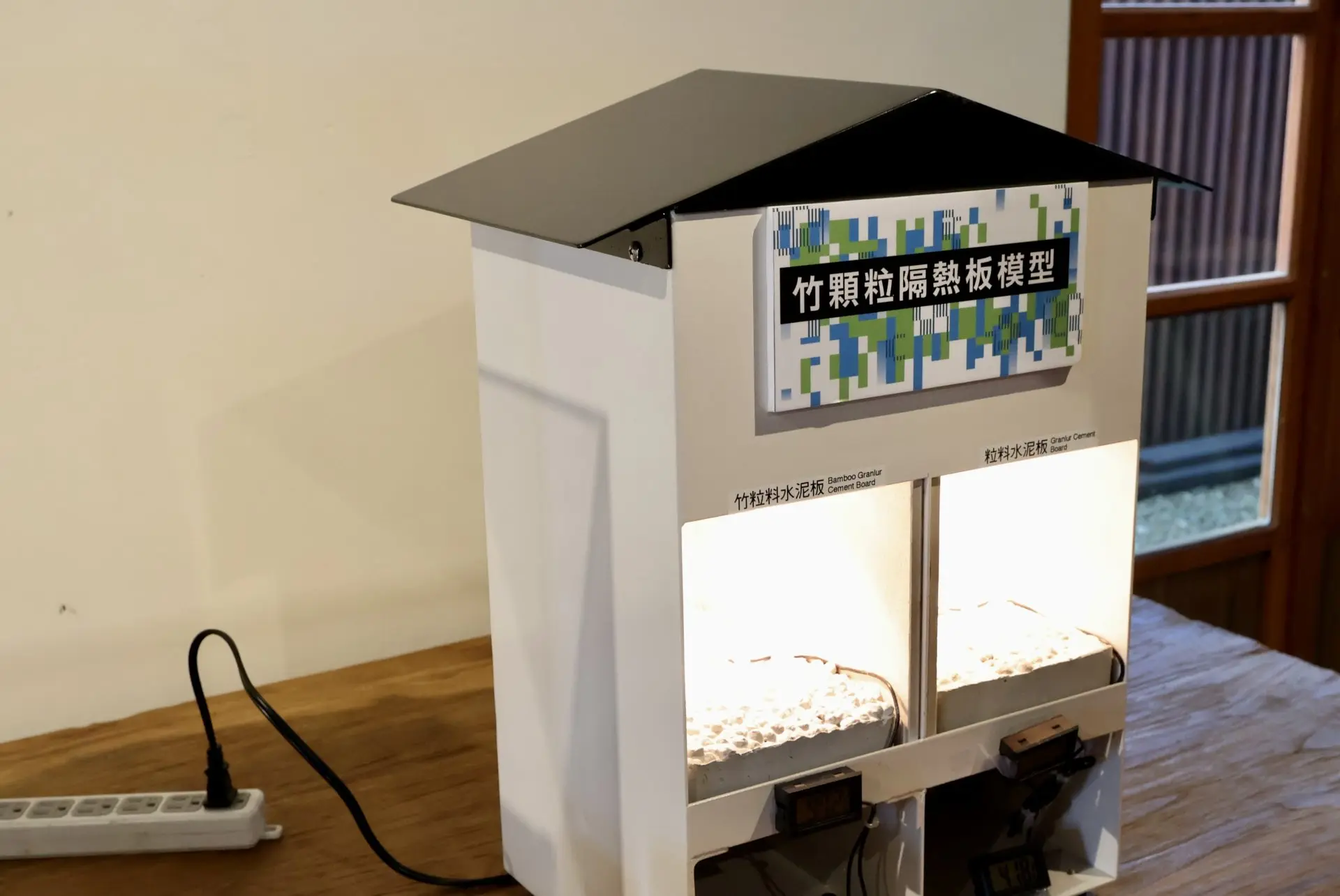 「竹顆粒隔熱板模型」展示裝置，以竹粒料水泥板與粒料水泥板對照，呈現竹材於建材隔熱的實驗成果。黎光棣攝