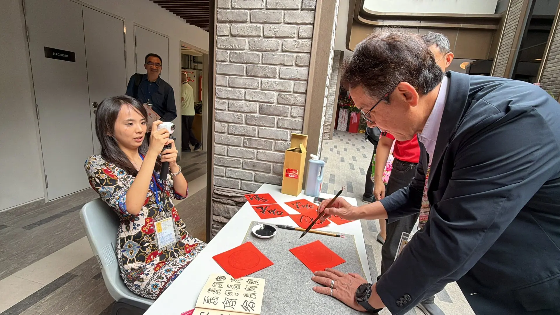 青年團成員梅耀慈於大埔客聚樓開幕活動安排「客」字書法體驗。北市客基會提供