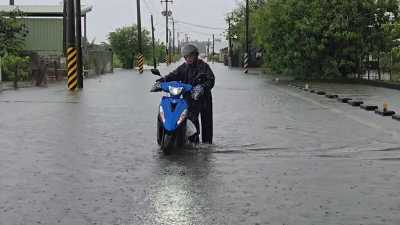 受低壓帶及西南風影響屏東大雨不斷、屏東東港24日多處淹水，民眾從大潭社區前往環美社區途中機車拋錨。中央社