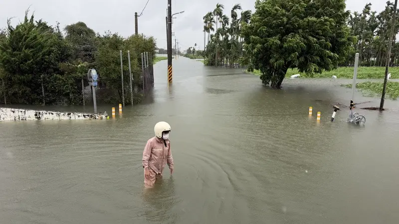 屏東近日大雨，萬丹鄉興農路淹水，24日上午有果農想涉水查看果園，但因積水太深而作罷。中央社