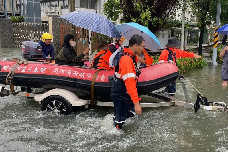 台南市安南醫院附近主要道路長和路24日上午雨後出現嚴重積水，造成民眾就醫不便，消防隊出動橡皮艇協助接駁病患。讀者提供，中央社