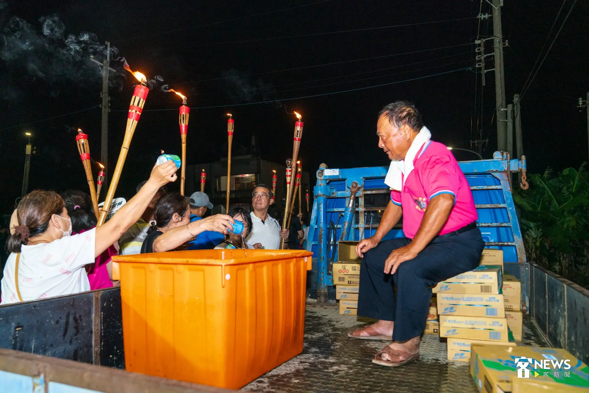 崙背水汴頭庄民手持竹製「澹仔火」遶行庄頭,沿途補給站提供涼水。洪藝晅攝