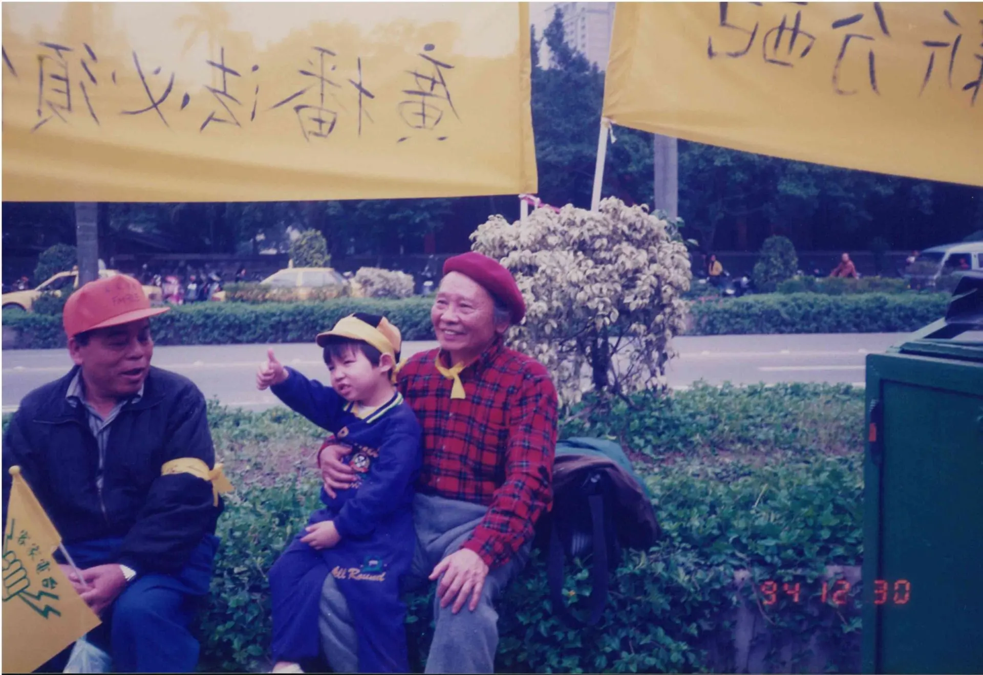 鍾肇政說:「童謠是和每個小孩活在一起的,它是每個小朋友的好朋友、好伴侶。」圖為鍾肇政(手抱小孩)參加寶島客家電台在立法院的抗爭活動。1994,台北。姜慧婷提供