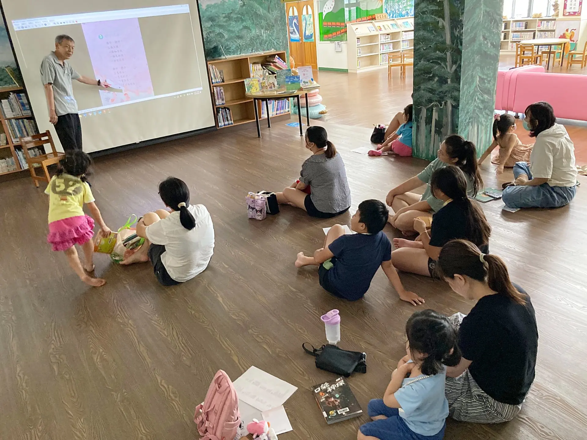 馮輝岳在三義圖書館帶領親子共下念創作的客家童謠〈豬仔摎雞仔〉。2025。廖文琪攝