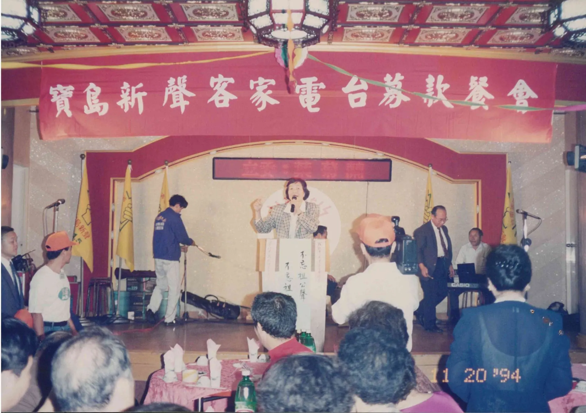 「不忘祖公聲，不忘祖宗言」是寶島新聲客家電台的宗旨。圖為葉菊蘭在募款餐會上大聲疾呼。1994，台北。姜慧婷提供