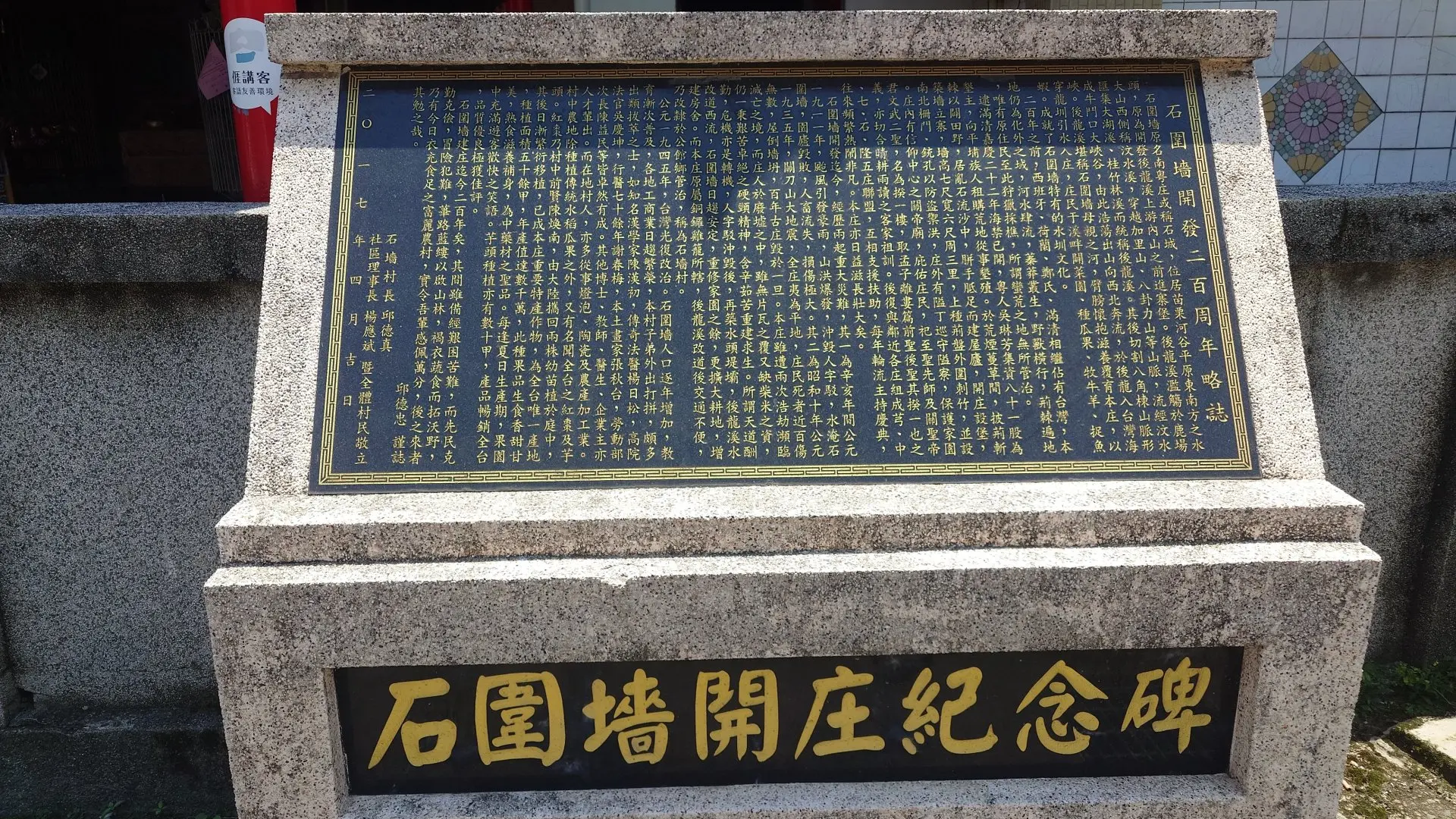 邱德忠在石圍墻開庄紀念碑，寫了「石圍墻開庄二百周年略記」，詳述石圍墻的開拓史。何來美攝