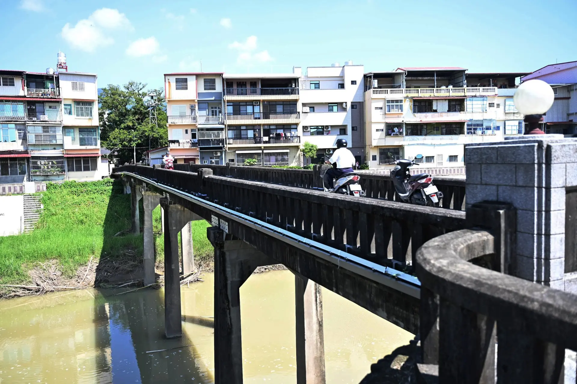 居民騎著機車過美濃舊橋，往來市場與街巷。Haka小姐攝