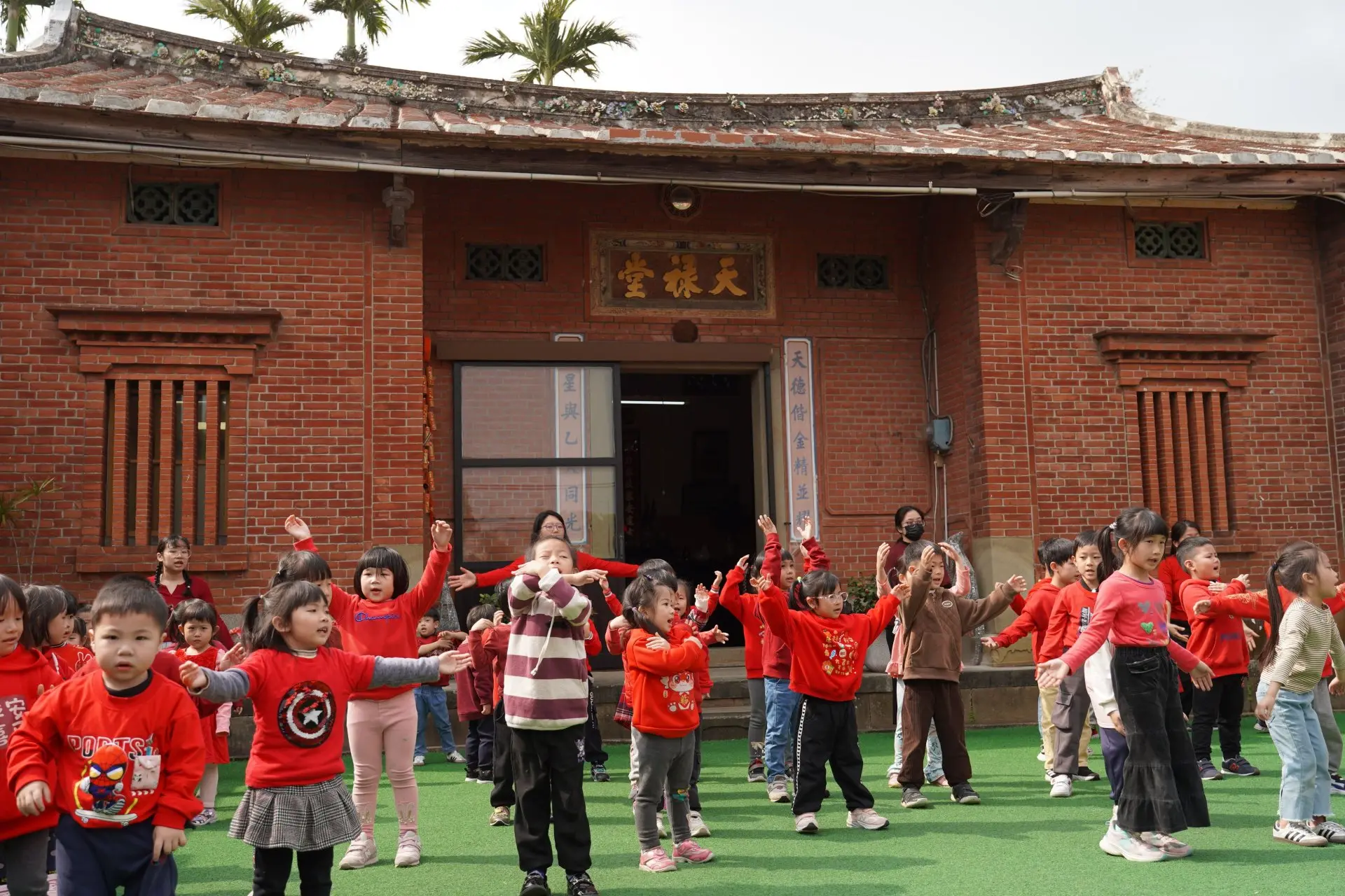 在新竹縣新埔鎮「天祿堂」內的親愛幼兒園，小朋友在三合院禾埕活動。新竹縣政府提供